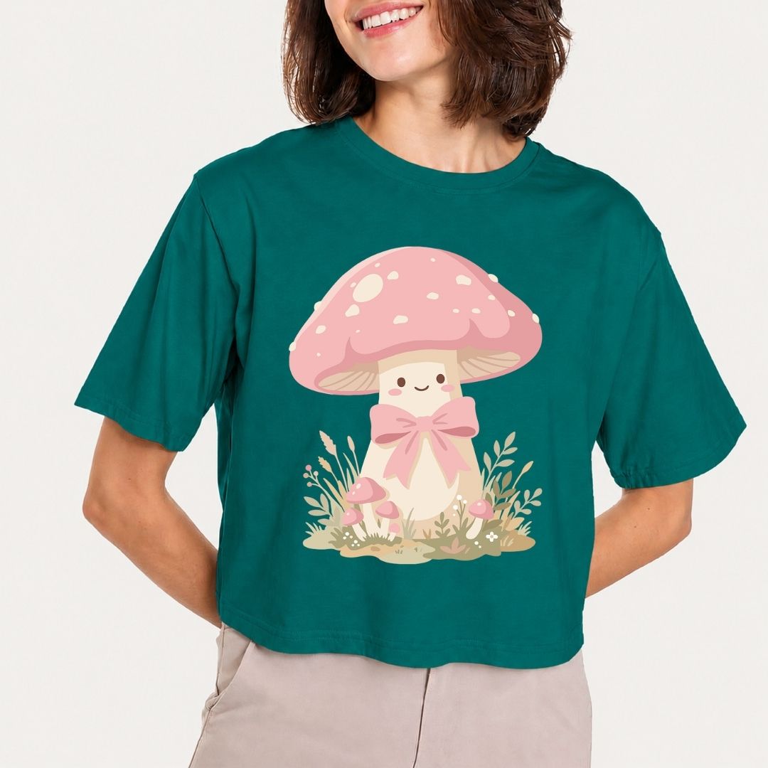 Person wearing a teal t-shirt with a cartoon mushroom design on a plain background