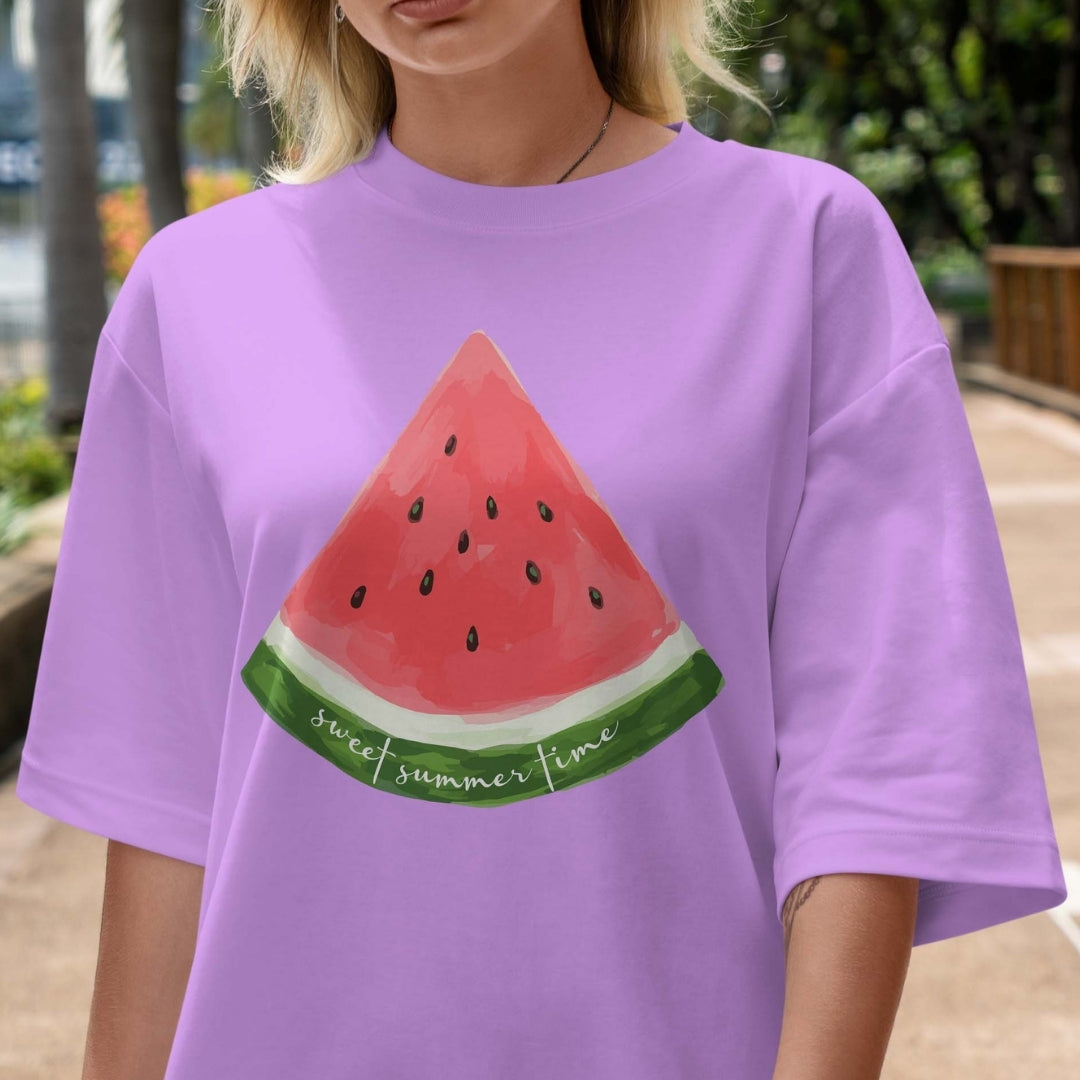 Person wearing a purple t-shirt with a watermelon design outdoors.
