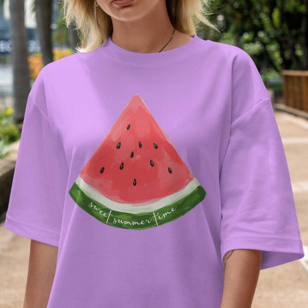 Person wearing a purple t-shirt with a watermelon design outdoors.