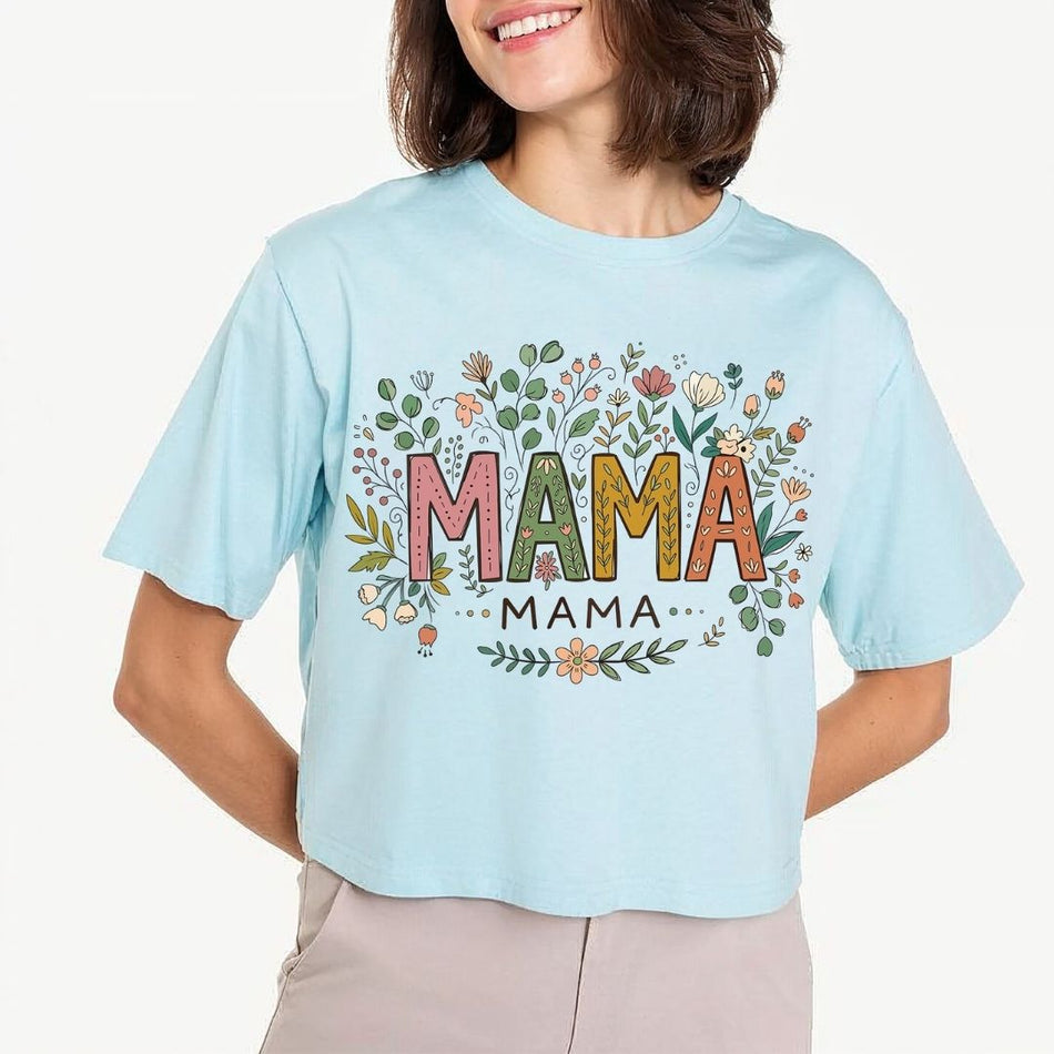 Light blue t-shirt with 'MAMA' print worn by a person on a white background