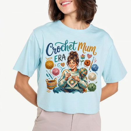 Person wearing a light blue t-shirt with 'Crochet Mum Era' design.