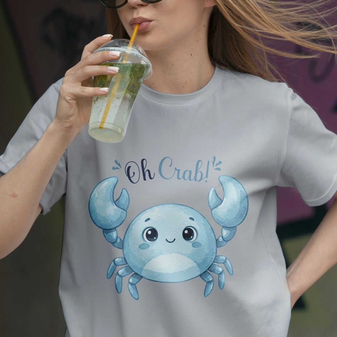 Person wearing a t-shirt with a blue crab design and 'Oh Crab!' text, holding a drink.