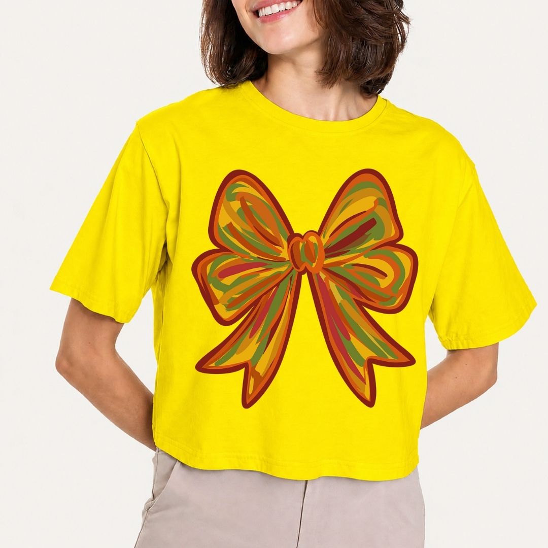 Person wearing a yellow t-shirt with a large colorful bow design on a plain background