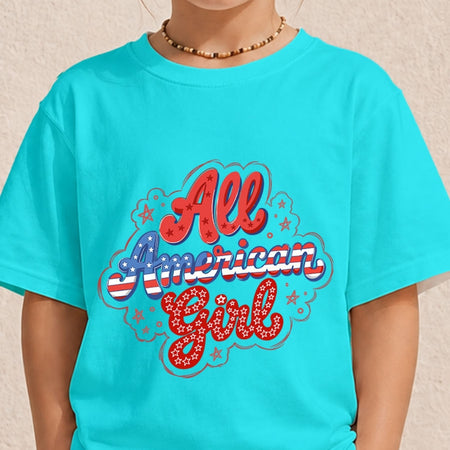 A child wearing a bright turquoise short-sleeve t-shirt with a patriotic graphic that reads 'All American Girl' in red, white, and blue lettering with stars.