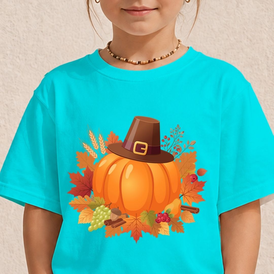 A child wearing a bright turquoise short-sleeve T-shirt with a large autumn graphic on the chest featuring an orange pumpkin, brown Pilgrim hat, and fall leaves.