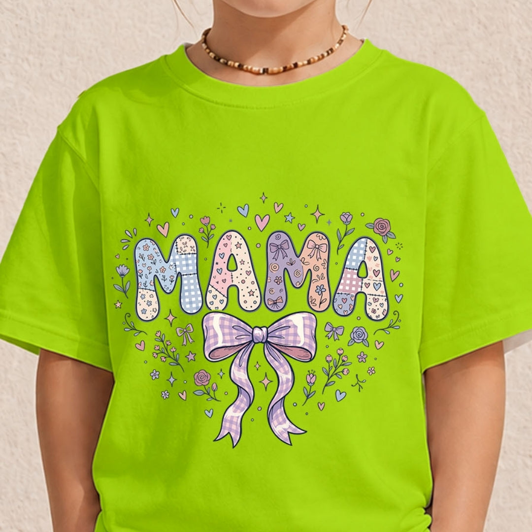 A child wearing a bright lime green t-shirt with a colorful graphic that reads 'MAMA' in patterned letters with a purple bow and floral details, set against a light beige textured wall.