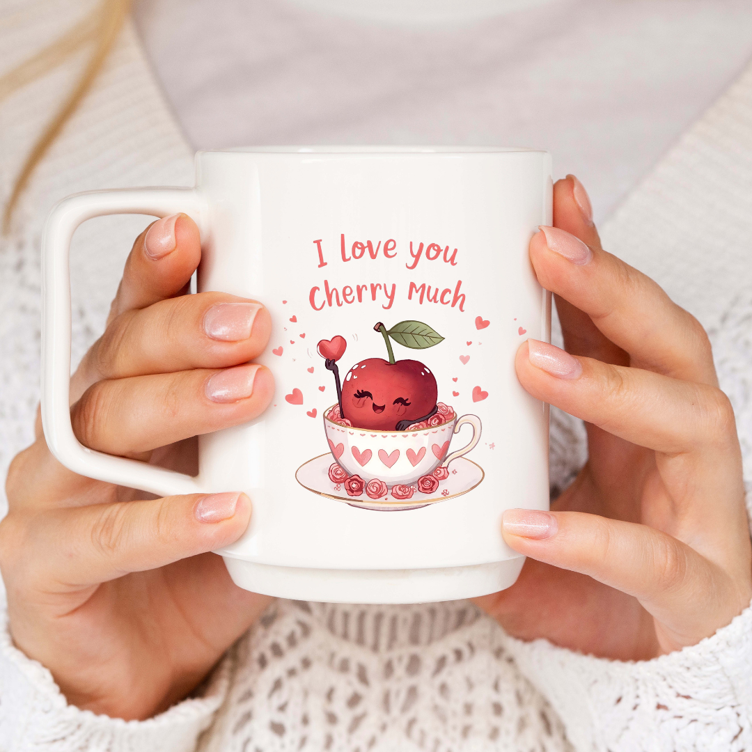 White mug with cherry-themed design and 'I love you cherry much' text, held by a person.
