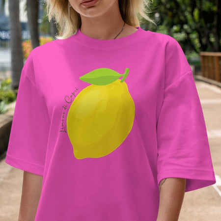 Person wearing a pink t-shirt with a lemon graphic outdoors