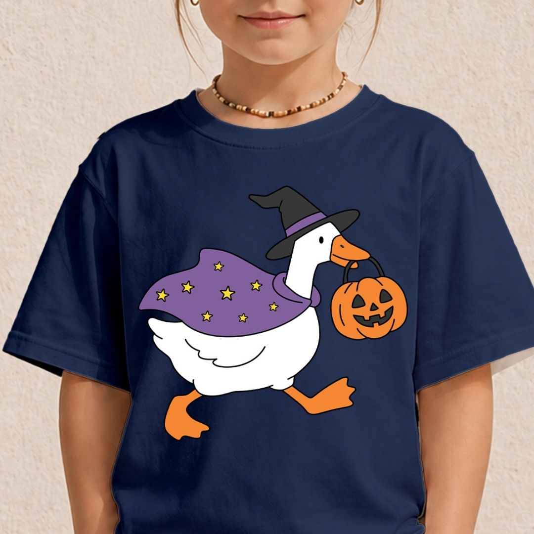 A child wearing a navy blue short-sleeve t-shirt with a cartoon graphic of a white goose dressed in a purple witch hat and cape, carrying a jack-o'-lantern pumpkin.