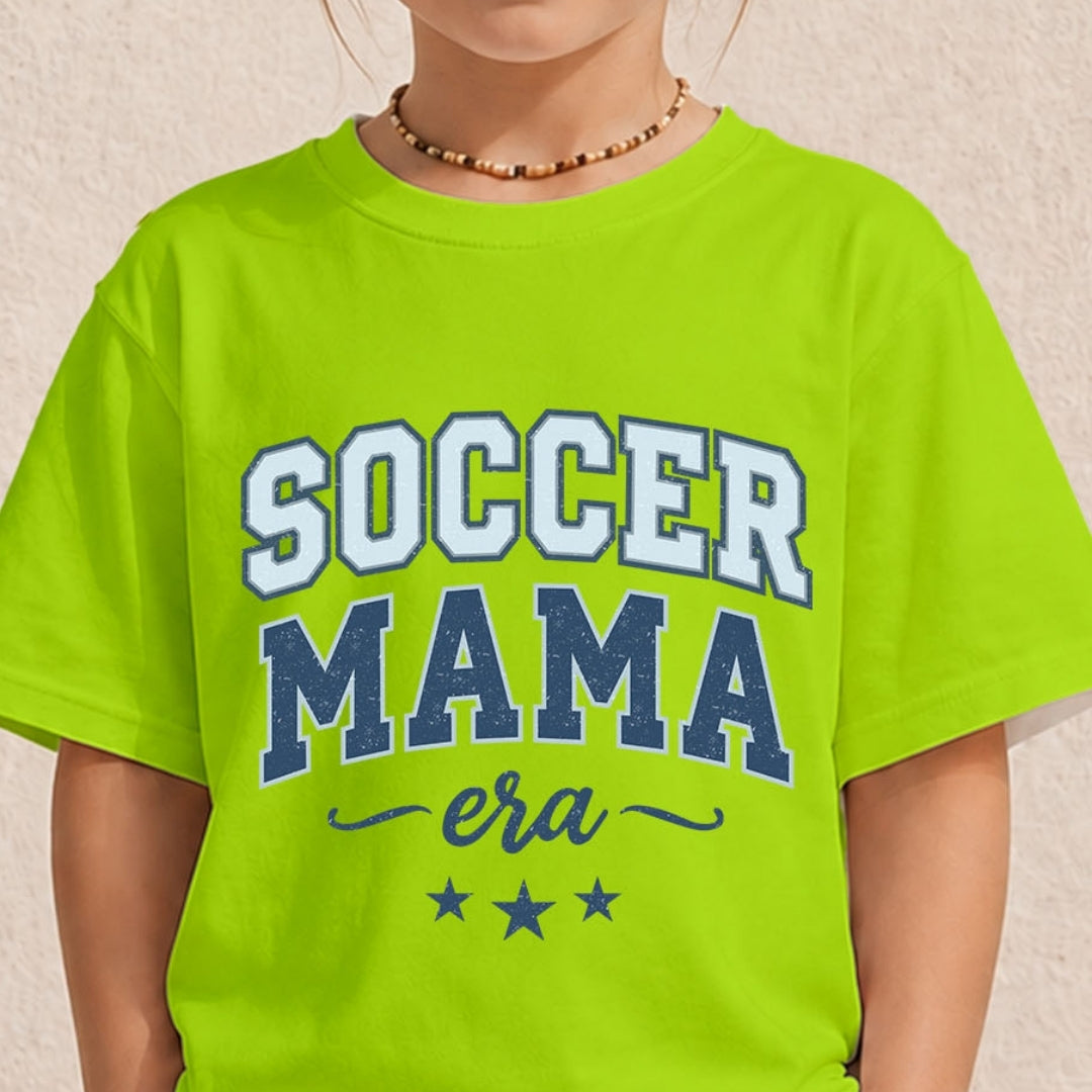 Close-up of a youth or toddler wearing a bright neon green t-shirt printed with a blue varsity-style "Soccer Mama Era" design.
