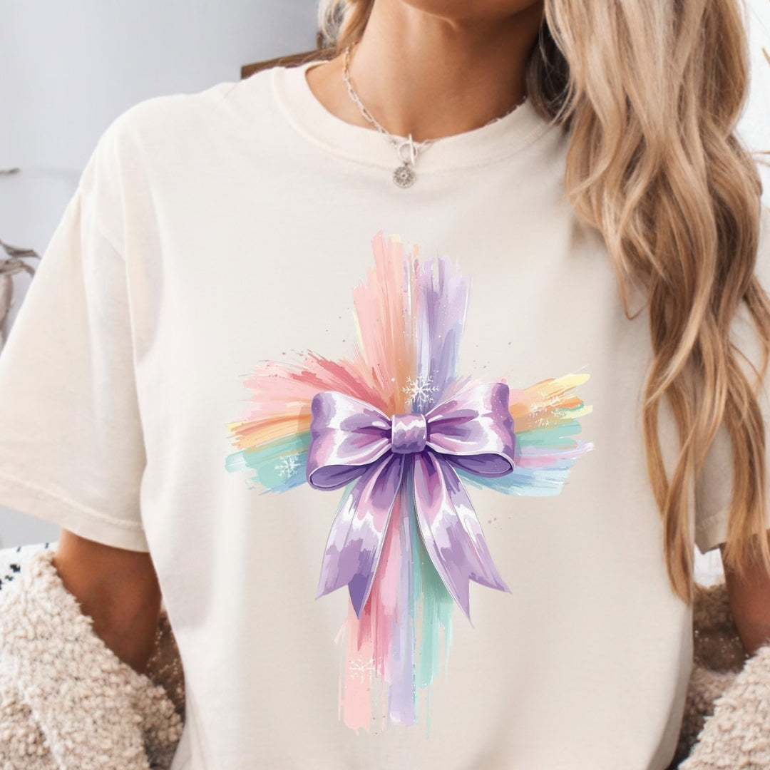 White t-shirt with a colorful bow design worn by a person.