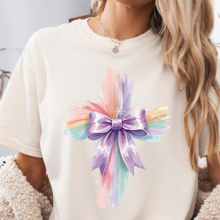 White t-shirt with a colorful bow design worn by a person.