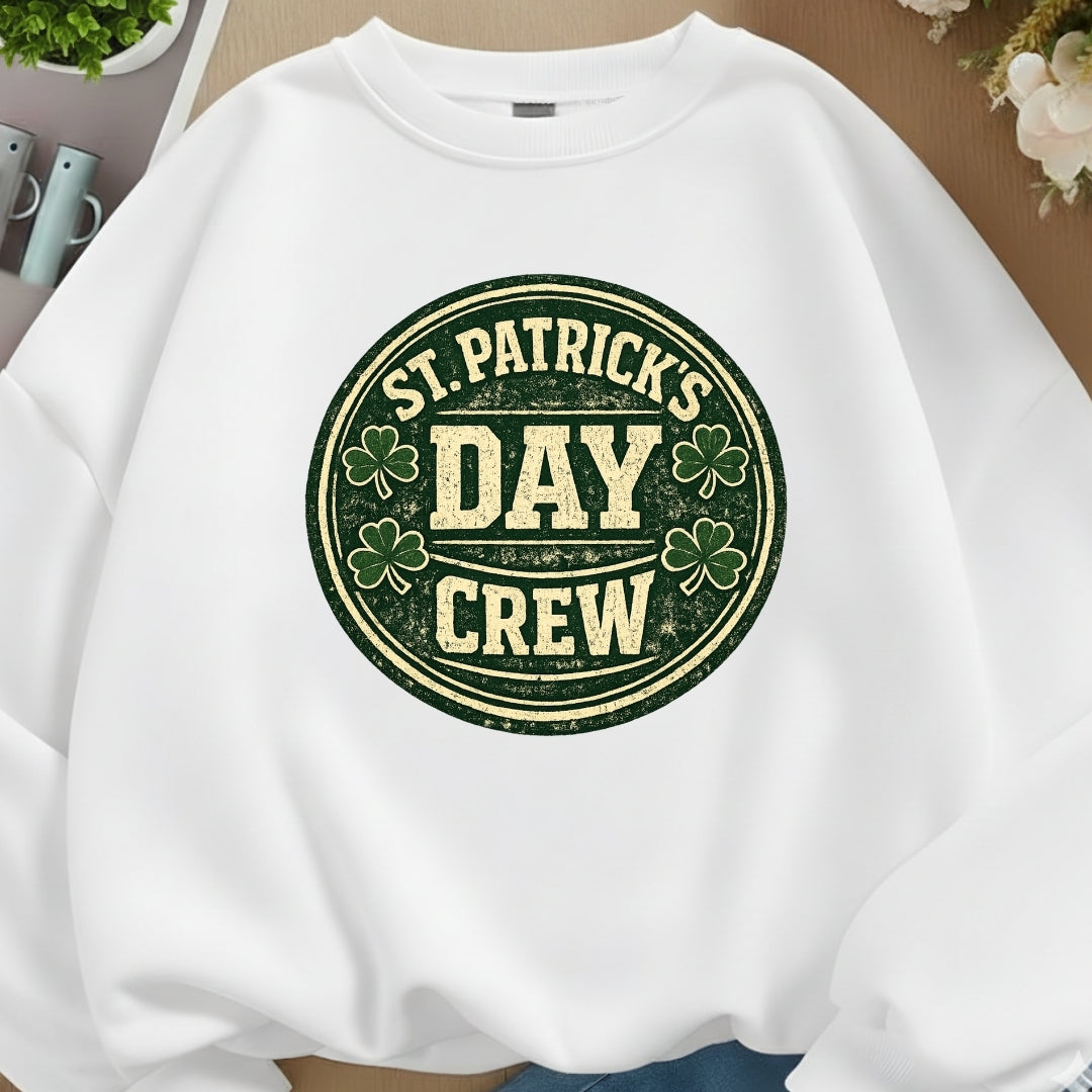 White sweatshirt with 'St. Patrick's Day Crew' text and shamrock design on a neutral background