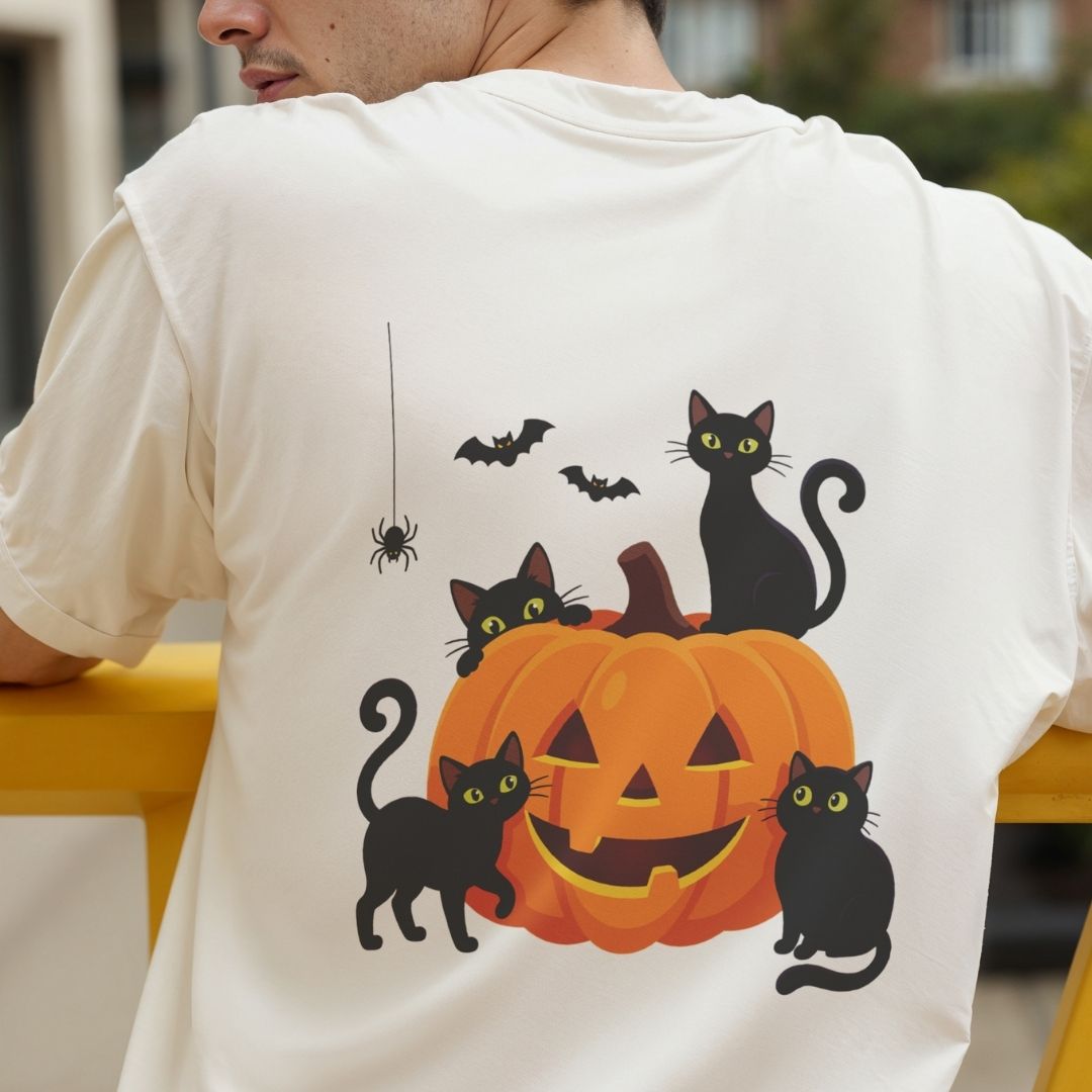Back view of a person wearing an off-white t-shirt featuring a vibrant cute Halloween black cats and pumpkin illustration
