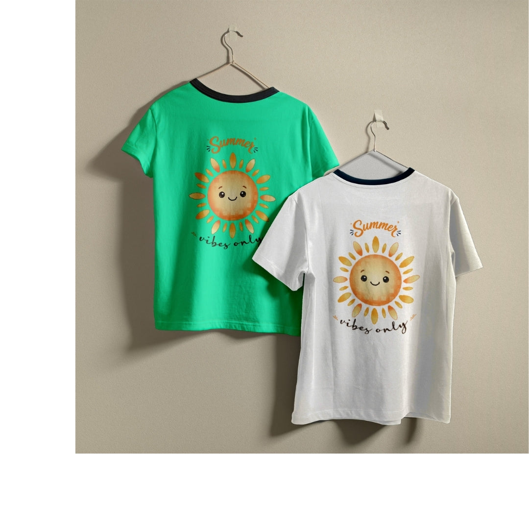 Two t-shirts hanging on hangers, one green and one white, both printed with a happy cartoon sun graphic and the text "Summer vibes only".