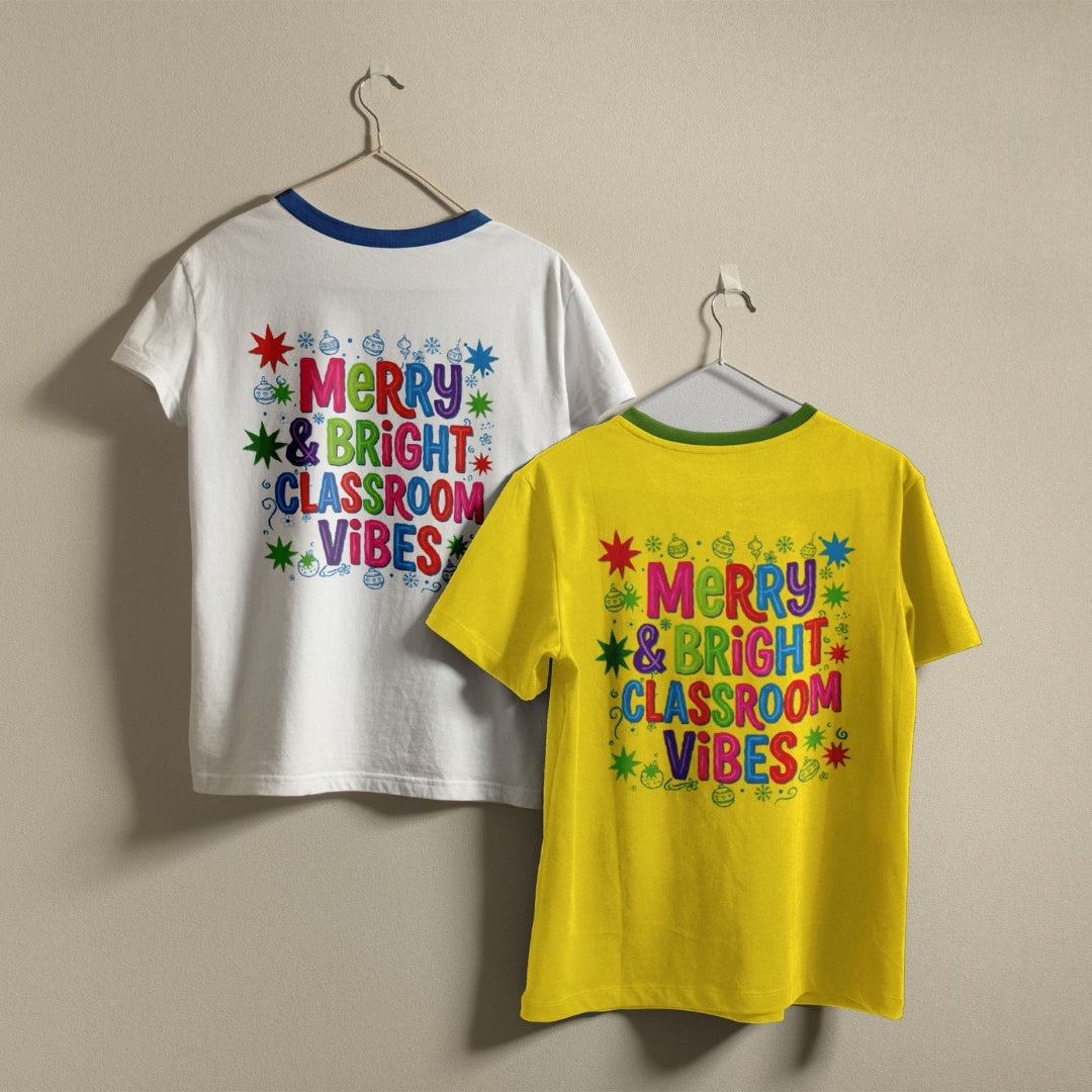 Two children's short-sleeve t-shirts hanging on hangers against a plain beige wall. The back of a white ringer t-shirt and the front of a bright yellow ringer t-shirt both feature a colorful retro-style graphic that reads 'MERRY & BRIGHT CLASSROOM VIBES' surrounded by stars and dots.