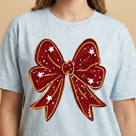 Light blue t-shirt with a large red bow design on a beige background