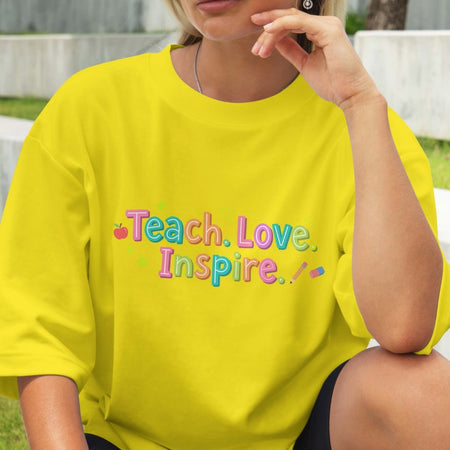 Person wearing a yellow shirt with 'Teach. Love. Inspire.' text.