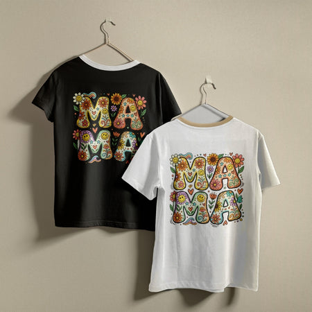 Two t-shirts hanging on a wall, one black and one white, both printed with a vibrant 1970s hippie style "MAMA" alphabet art graphic.
