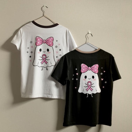 Two short-sleeve ringer T-shirts hanging on hangers against a plain beige wall. One white shirt shows a back graphic of a cute ghost with a pink bow and pink ribbon, and one black shirt shows the front graphic of the same ghost design.