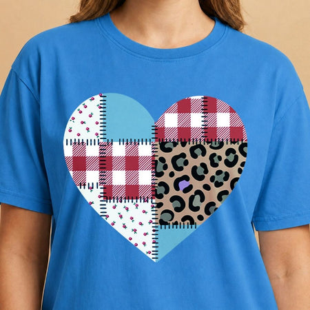 Blue t-shirt with a heart-shaped pattern featuring plaid and leopard print designs on a beige background.