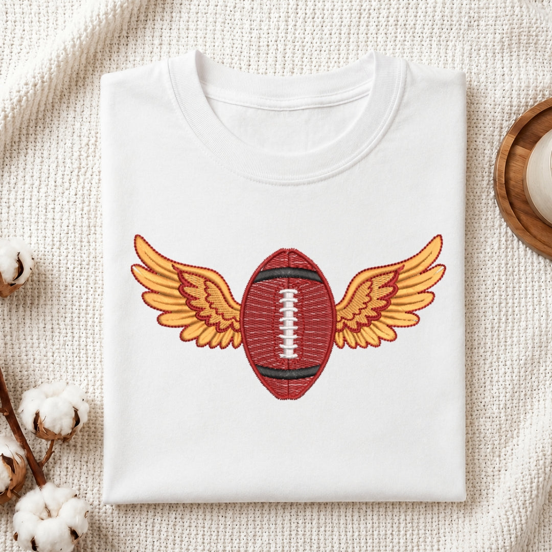 White sweatshirt with a football design featuring wings on a textured surface.