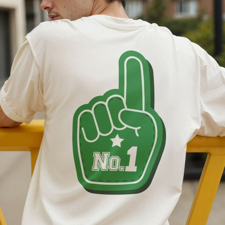 A man viewed from behind wearing a white t-shirt with a large green foam finger graphic on the back featuring the text 'No.1'.