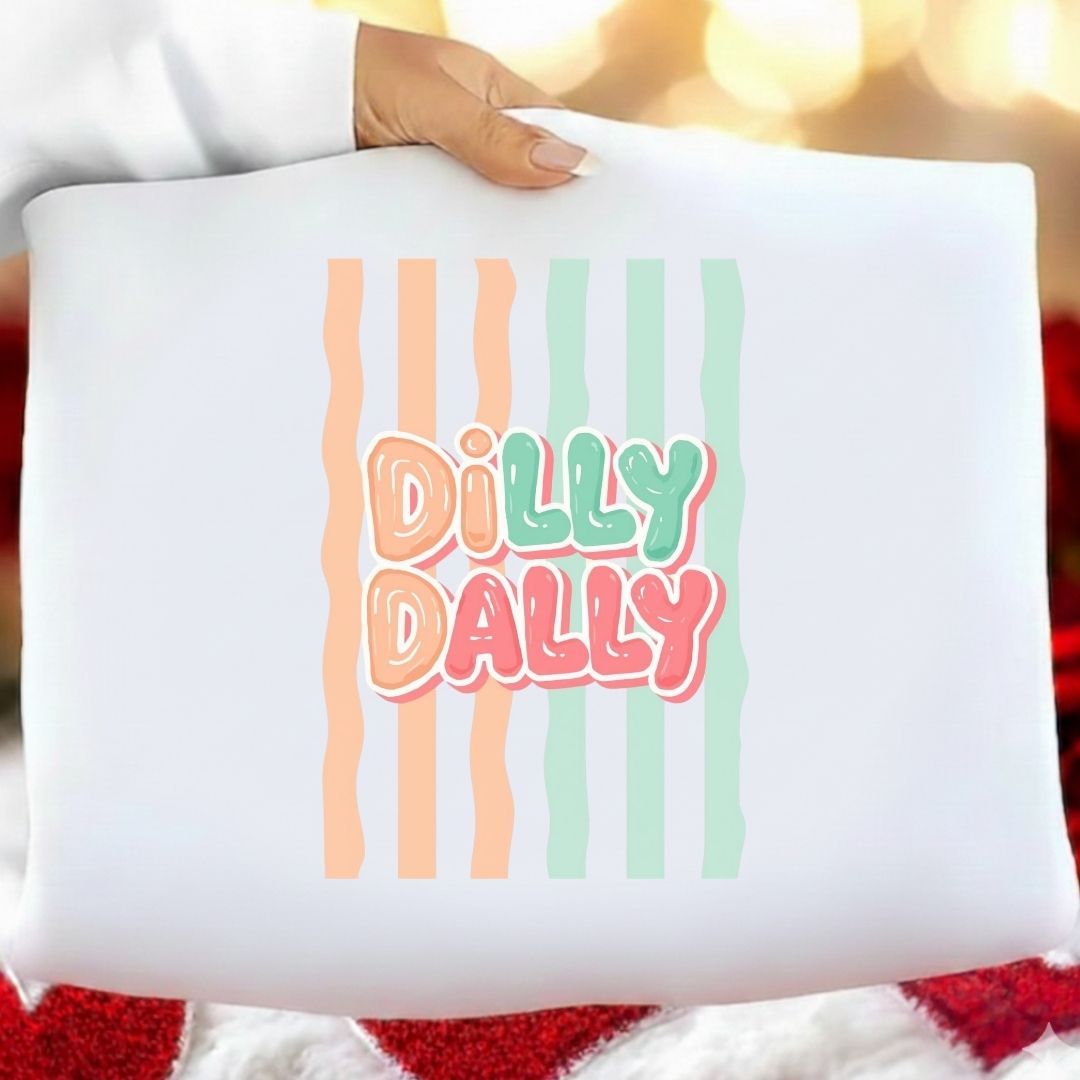 Pillow with 'Dilly Dally' text and colorful stripes held by a person.