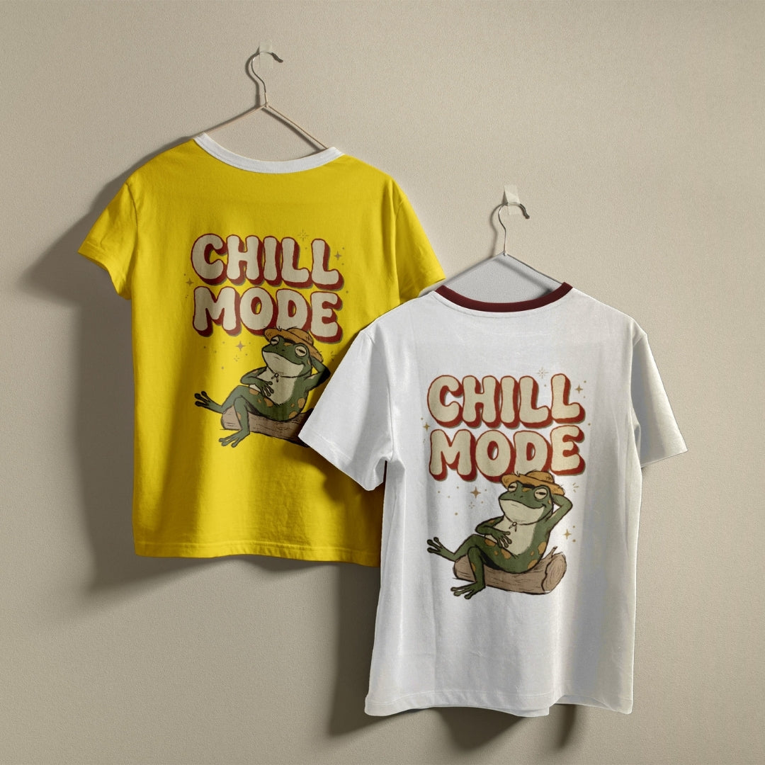 Two ringer t-shirts hanging on hangers against a plain beige wall. The left shirt is bright yellow with a white collar and features a graphic of a frog and the text 'CHILL MODE' in brown and orange.