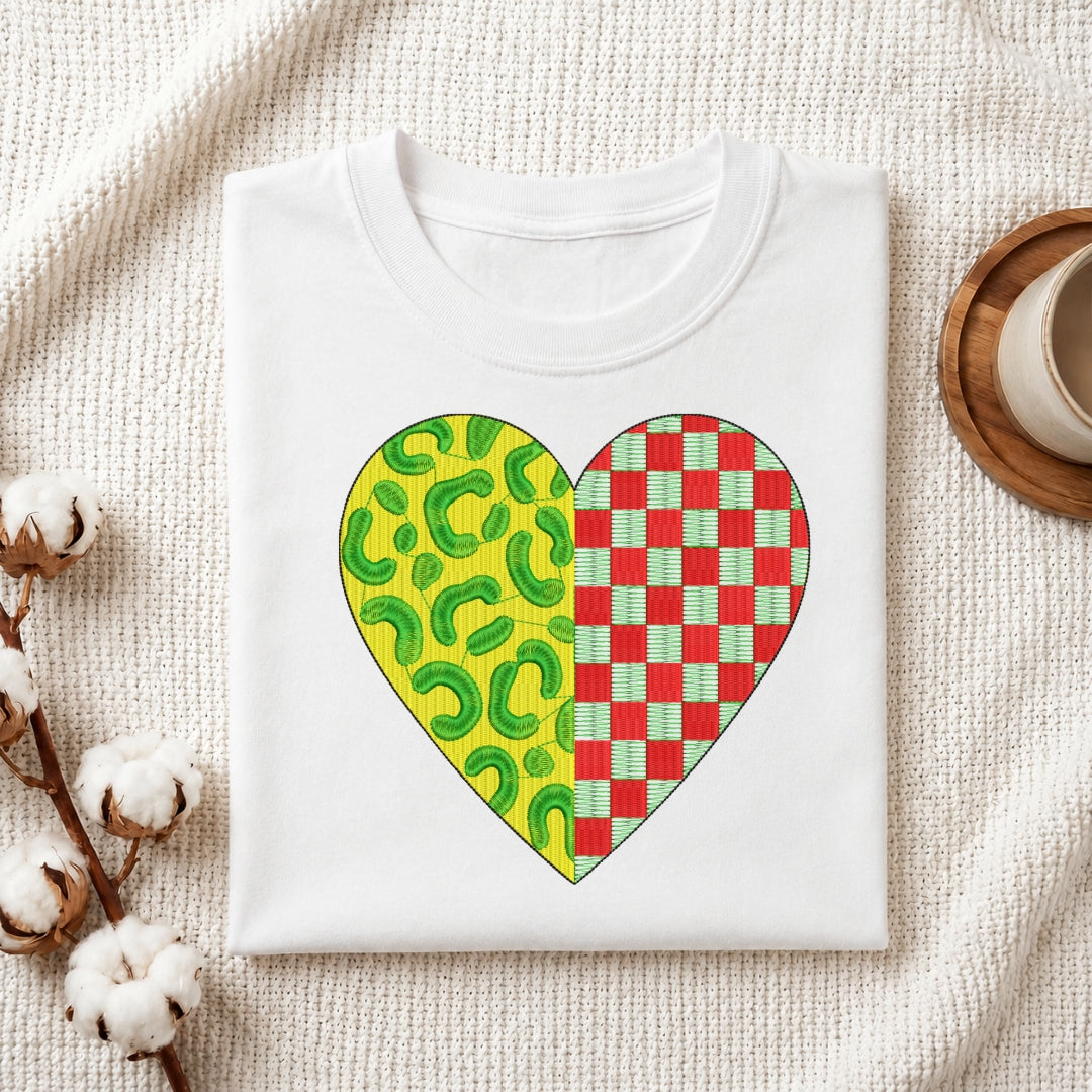 A neatly folded white t-shirt featuring a heart-shaped embroidery design with a split leopard print and red checkered pattern.