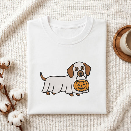 Folded white cotton t-shirt mockup featuring a ghost dachshund machine embroidery design, styled with cotton stems and a wooden cup   