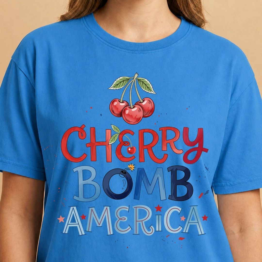 Blue t-shirt with 'Cherry Bomb America' graphic and cherries on a beige background