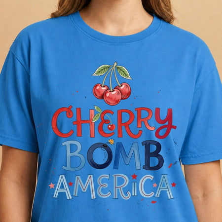 Blue t-shirt with 'Cherry Bomb America' graphic and cherries on a beige background