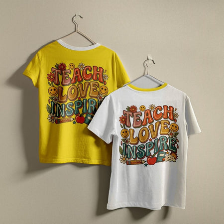 Bright yellow and white t-shirts hanging on a wall, both displaying the colorful "TEACH LOVE INSPIRE" teacher graphic printed on the back.
