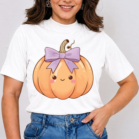 A woman wearing a white short-sleeve t-shirt with a cute cartoon pumpkin graphic on the front, paired with blue jeans, against a plain light gray background.
