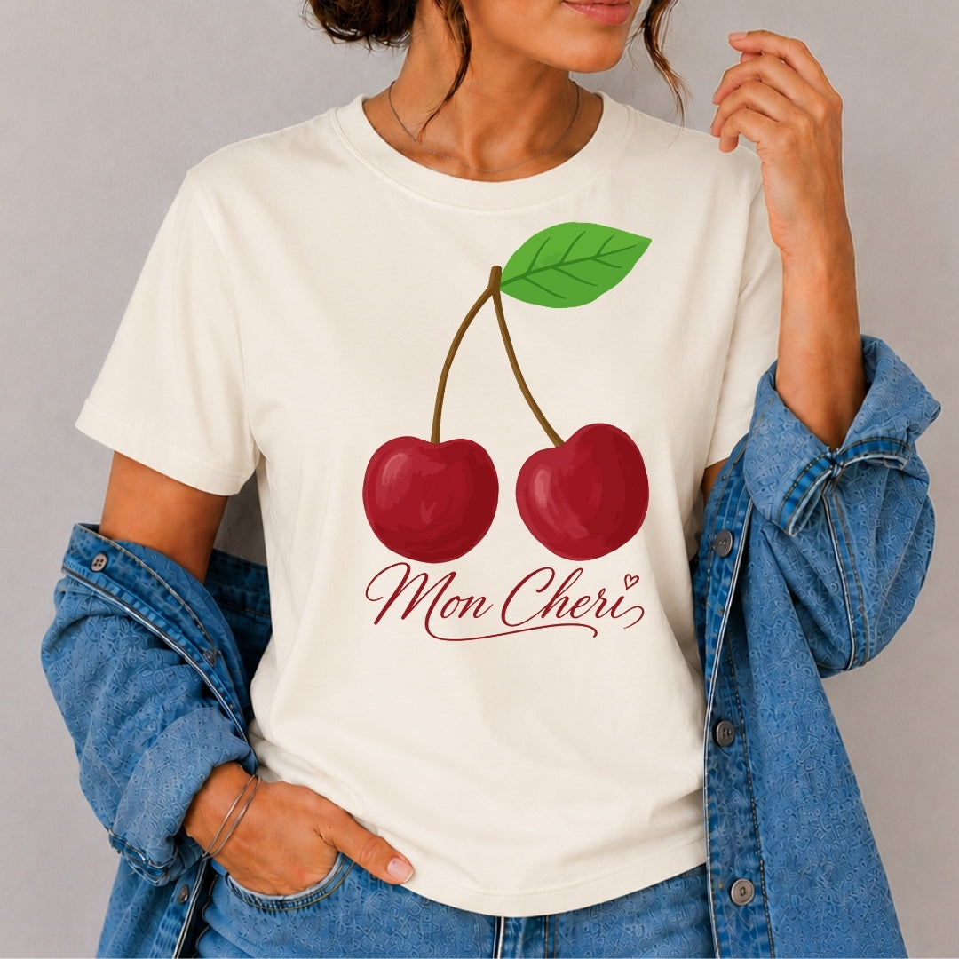 Person wearing a white t-shirt with cherry design and 'Mon Cheri' text.