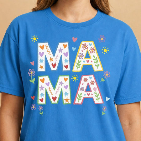 Blue t-shirt with colorful 'MAMA' text on a beige background