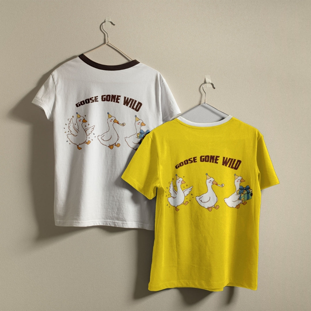 White and yellow t-shirts hanging on a wall, both displaying the humorous "GOOSE GONE WILD" partying geese graphic printed on the back.