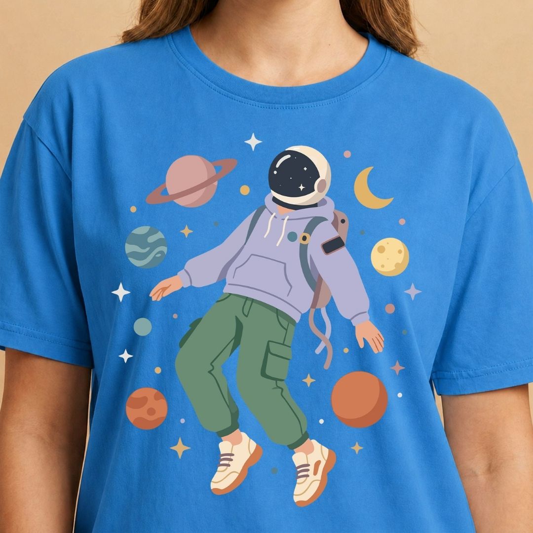 Person wearing a blue t-shirt with an astronaut graphic and space-themed design.
