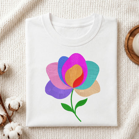 White t-shirt with a colorful flower design on a textured surface.