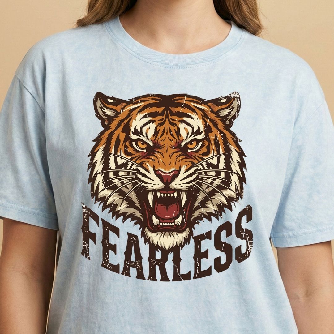 Light blue t-shirt with a tiger graphic and 'FEARLESS' text on a beige background