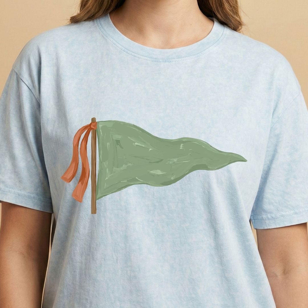 Light blue t-shirt with a green flag design on a beige background