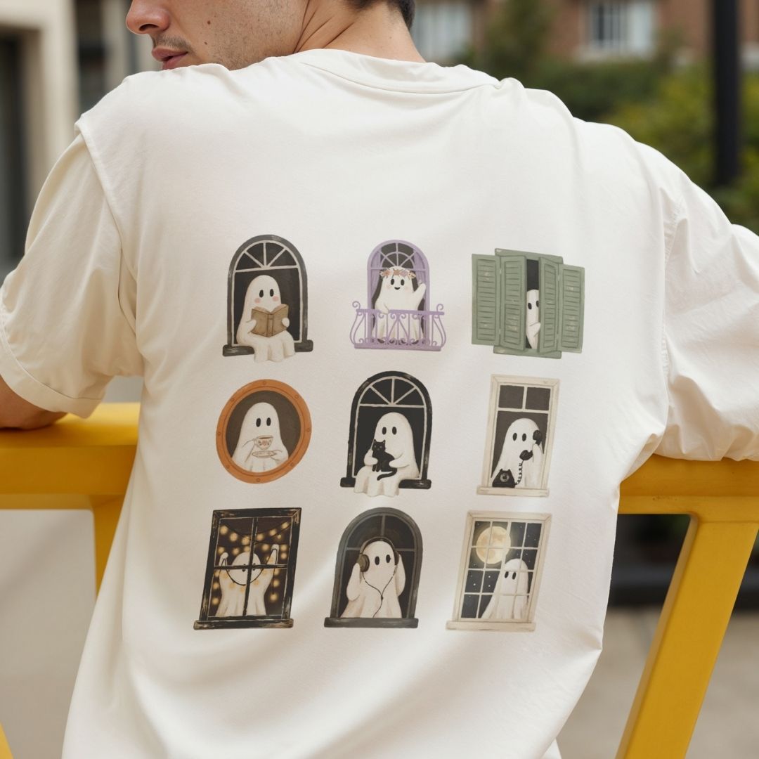 A person wearing a white short-sleeve T-shirt, shown from the back. The shirt features a large graphic print of nine cute cartoon ghosts in various window frames and arches.