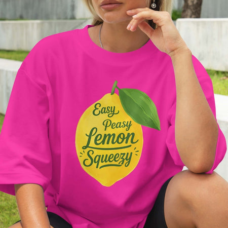 Person wearing a pink t-shirt with a lemon graphic and text.