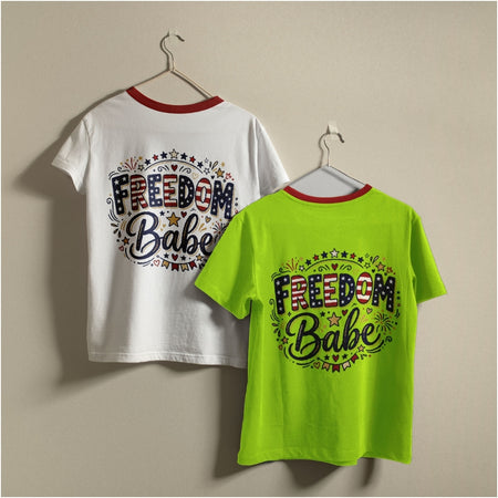 Two ringer-style graphic T-shirts hanging on hangers against a plain beige wall. One shirt is white with a red collar trim, and the other is bright neon green with a red collar trim.