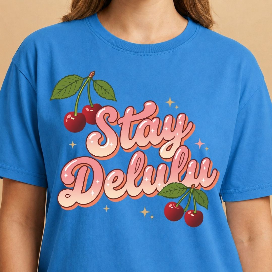 Blue t-shirt with 'Stay Delulw' text and cherry graphics on a beige background