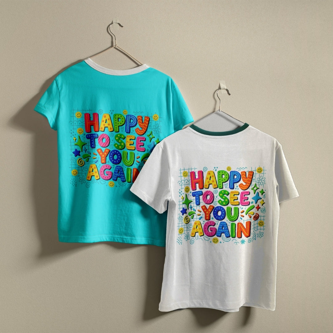 Two children's short-sleeve T-shirts hanging on hangers against a plain beige wall. The left shirt is turquoise blue with a colorful retro-style graphic reading 'HAPPY TO SEE YOU AGAIN' on the back.
