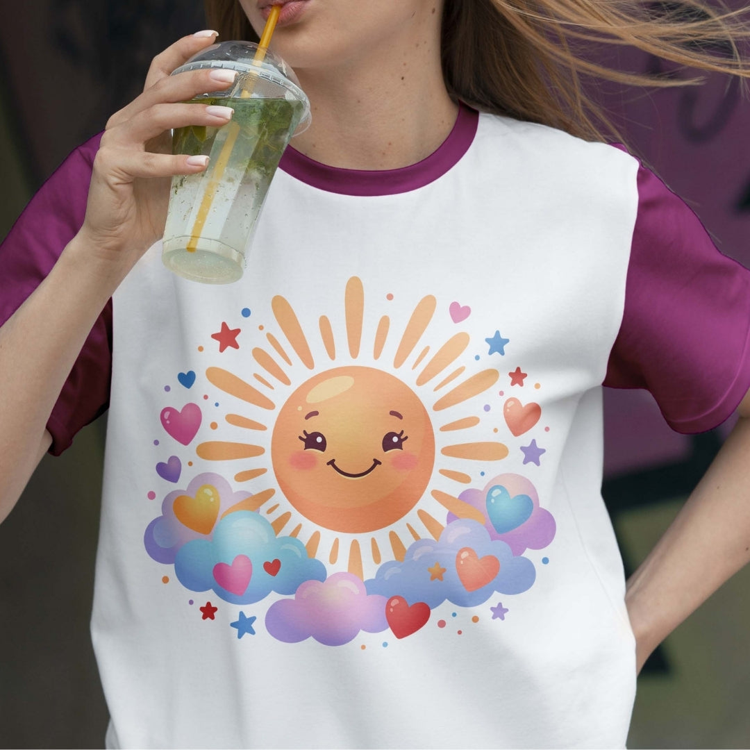 Person wearing a t-shirt with a sun and cloud design, holding a drink.