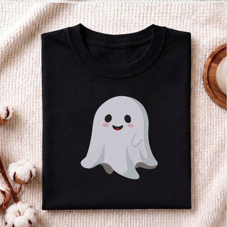 Folded black cotton t-shirt mockup featuring a cute smiling ghost machine embroidery design, styled with cotton stems and a wooden cup   