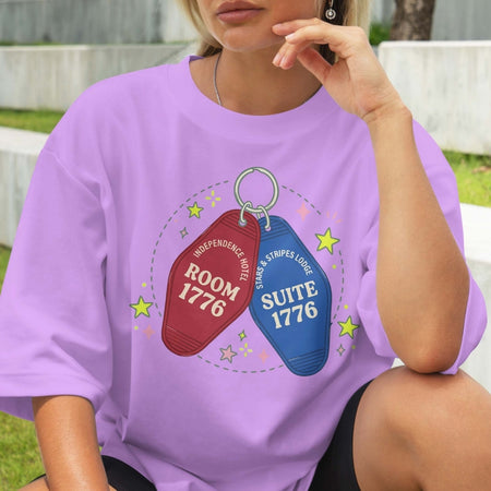 Person wearing a purple t-shirt with room and suite keychain graphics and text.